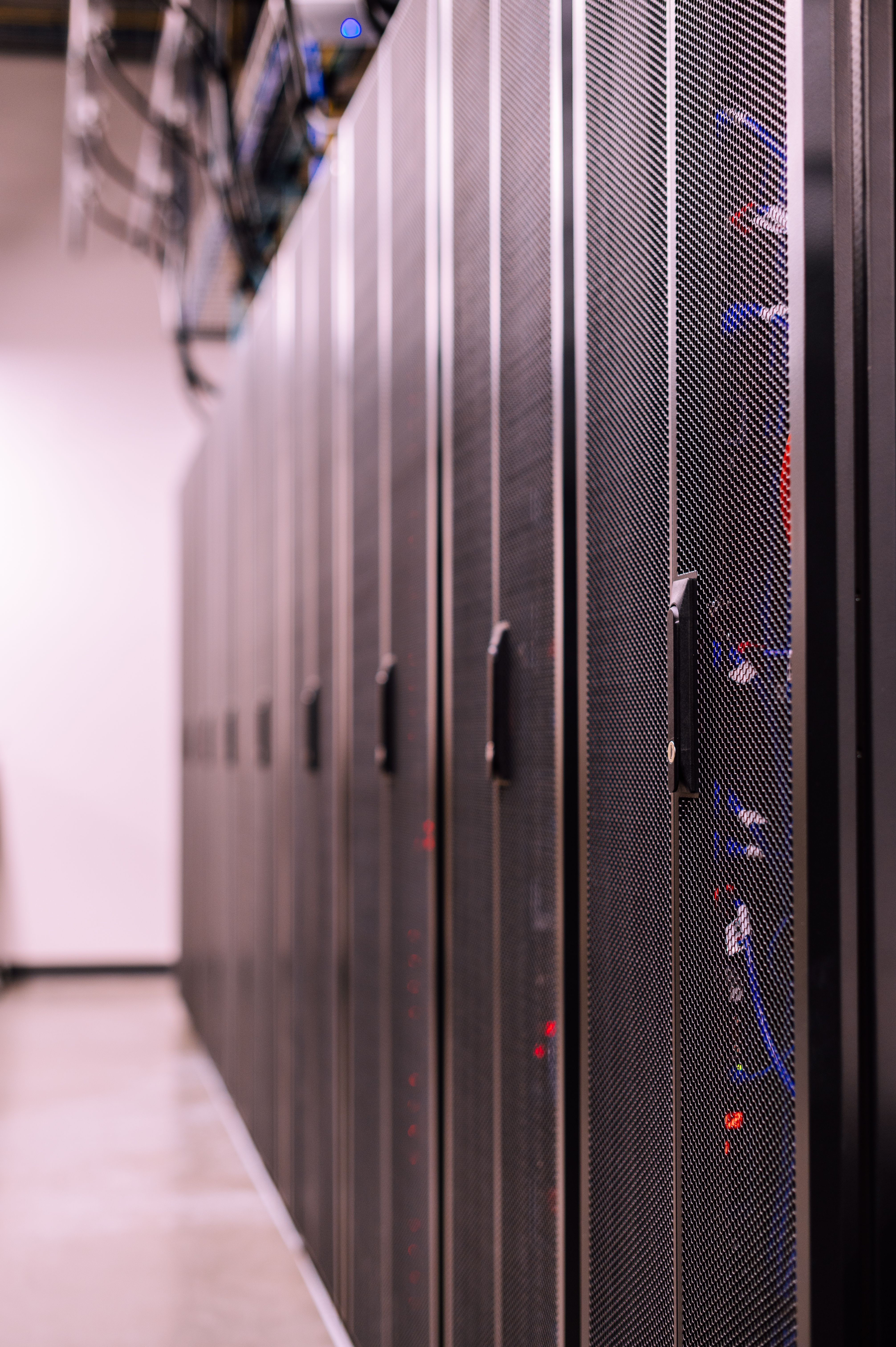 An aisle of server racks in a data hall.