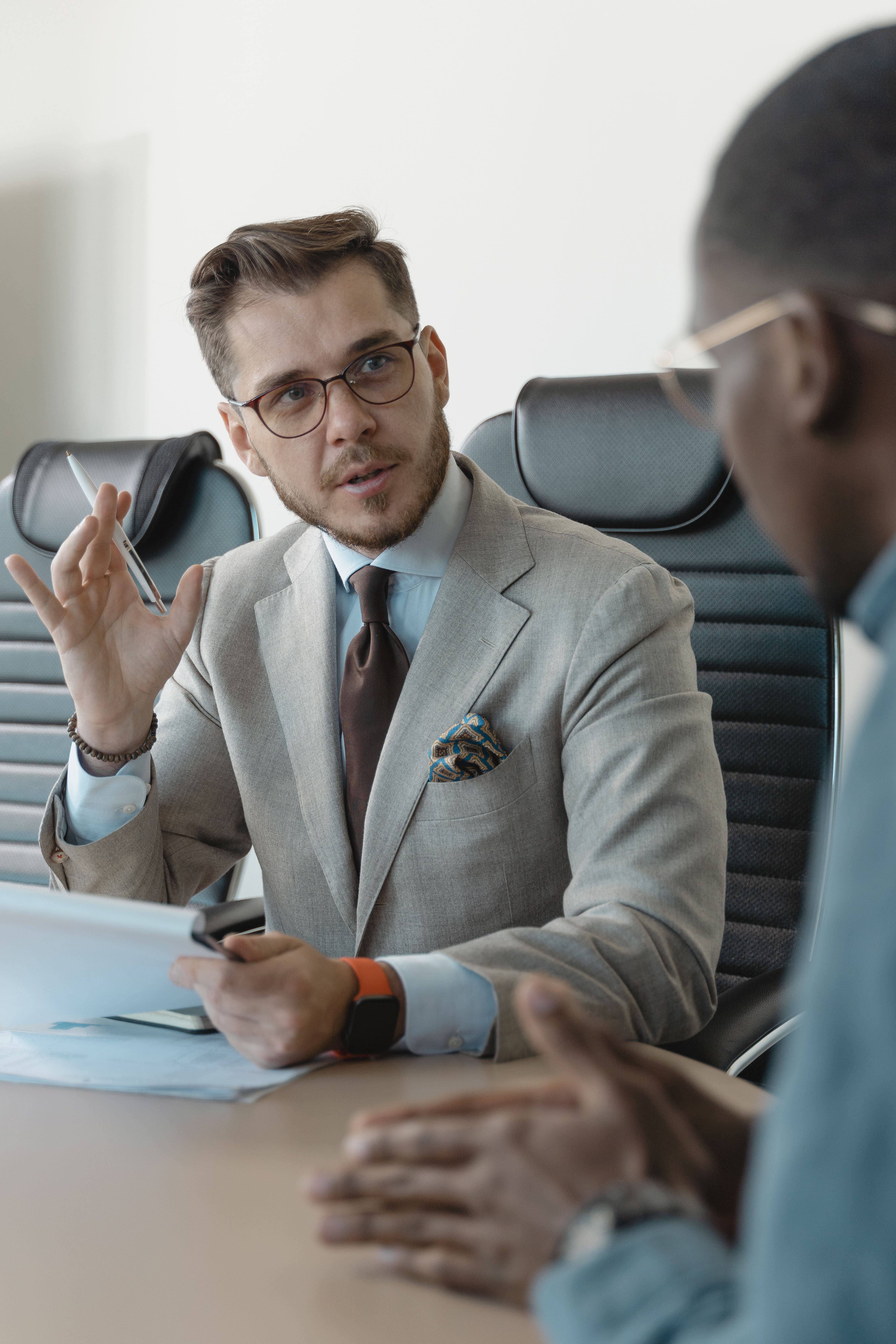 A commercial director in discussion across a meeting table.