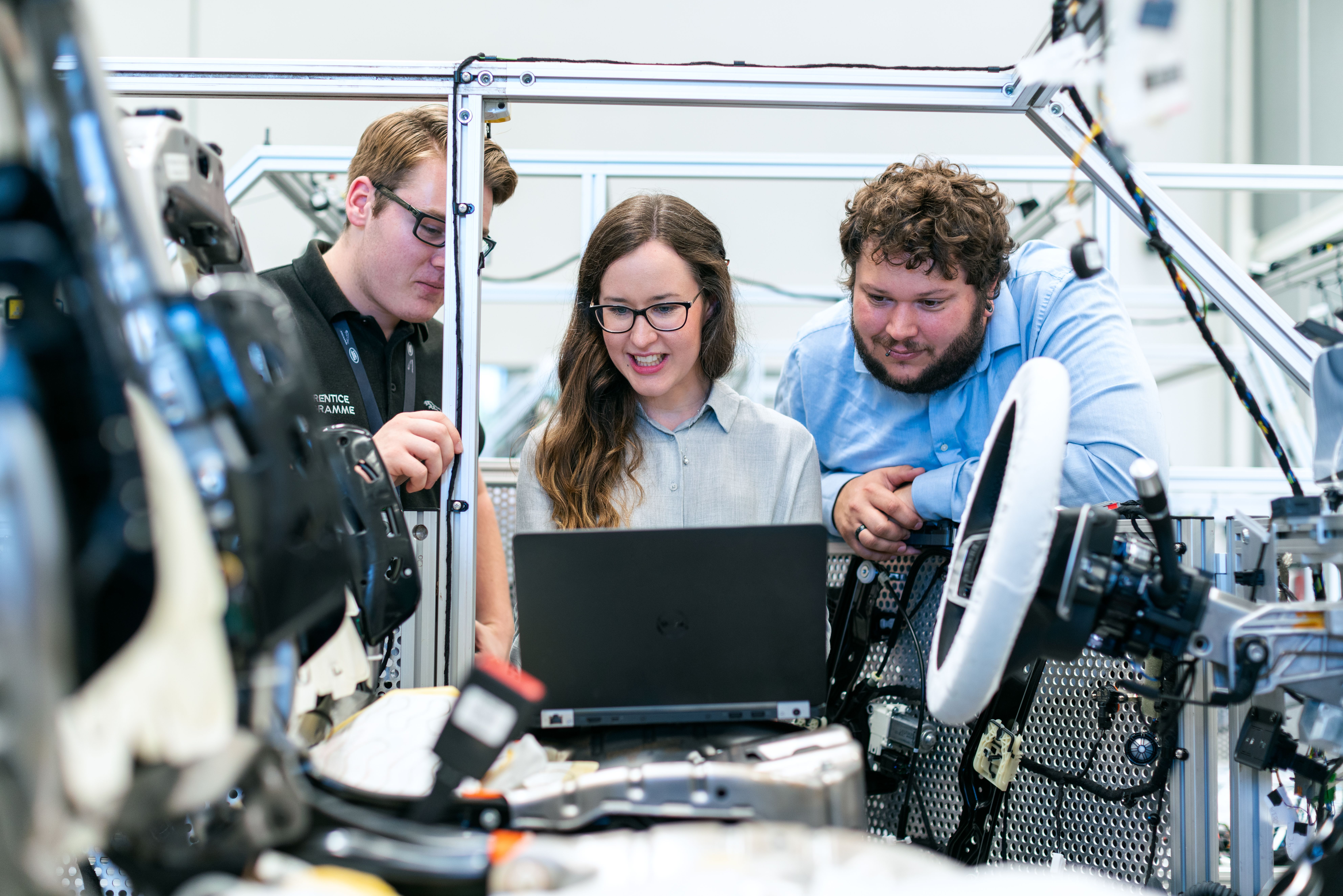 Engineers reviewing data on a laptop beside working equipment.